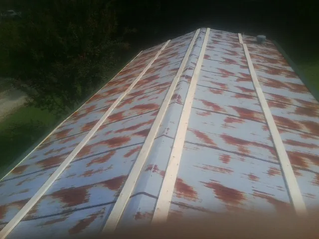 Rusted metal roof panels with new wood purlins before replacement — Storm Damage Roof Repair in Falkland by Roofing Brothers