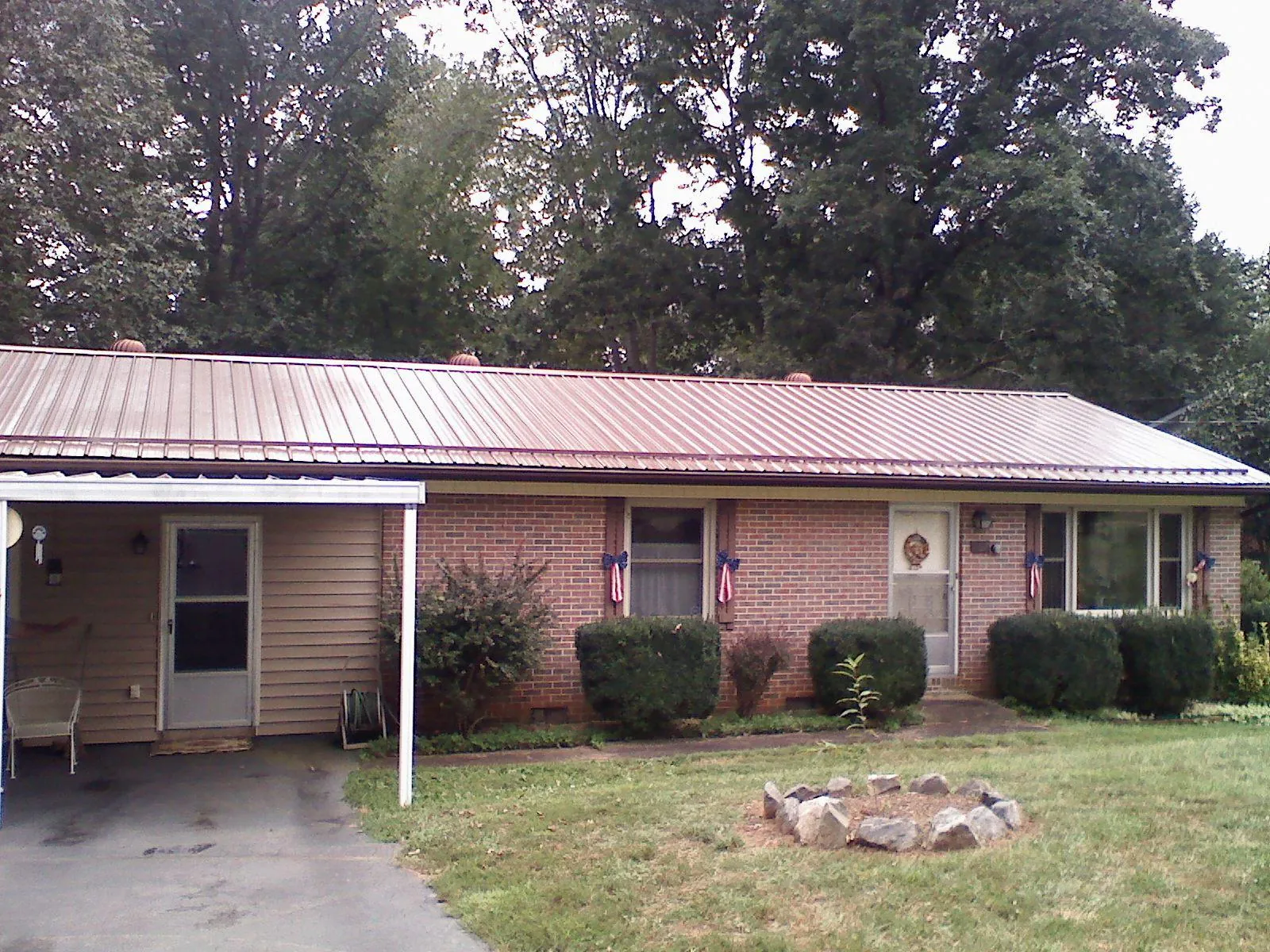 Bronze metal roof and carport on a brick ranch home — Roof Repair work by our crew in Falkland